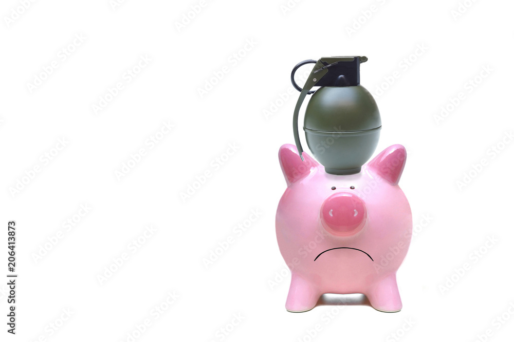 A hand grenade on a pink piggy bank / Terrorism threatening economy concept A hand grenade on a pink piggy bank / Terrorism threatening economy concept