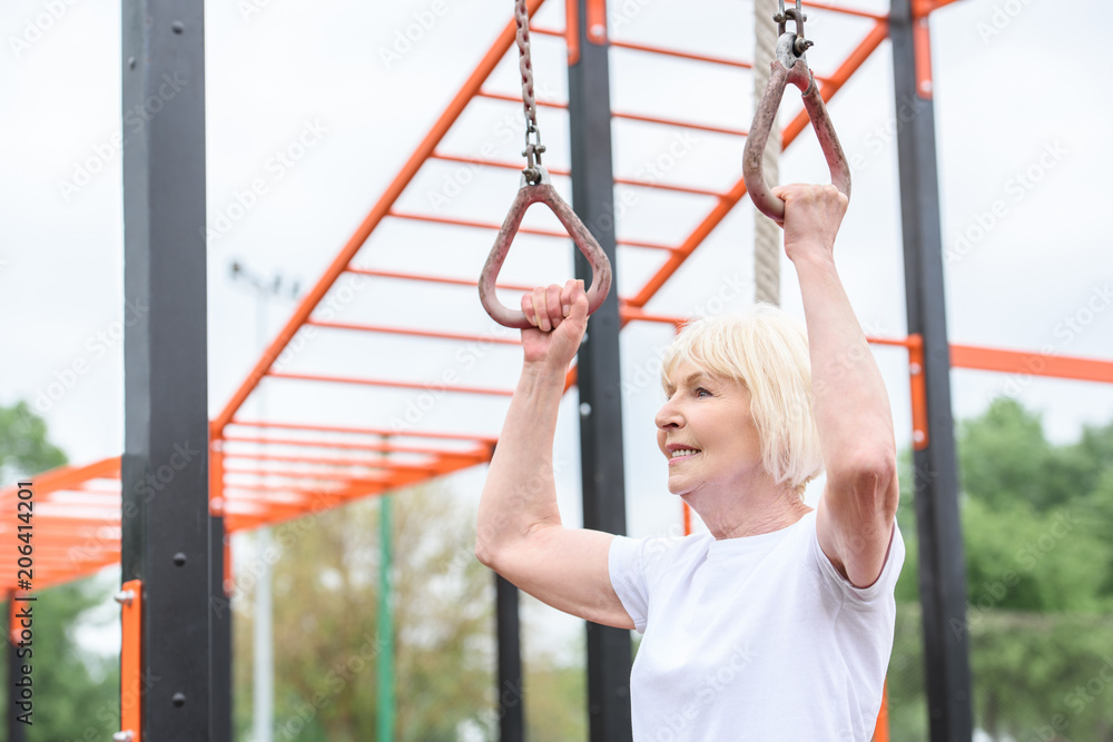 senior sportswoman training on rings on sports ground senior sportswoman training on rings on sports ground