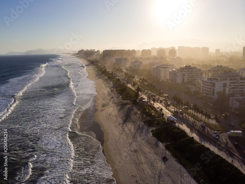 Aerial view of Barra da Tijuca beach during late afternoon with hazy sky and golden light. Rio de Janeiro, Brazil.