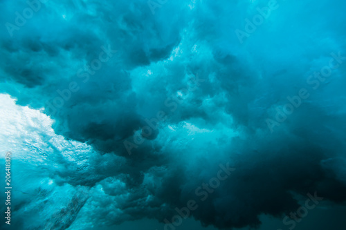 Breaking wave underwater. Blue ocean in underwater