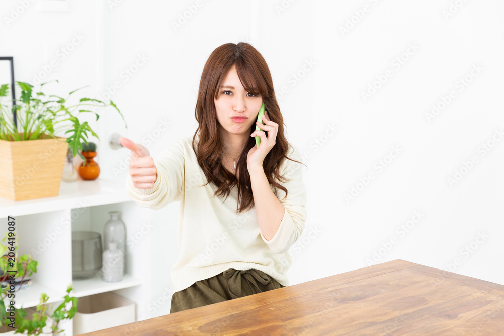 部屋で電話をする女性 部屋で電話をする女性