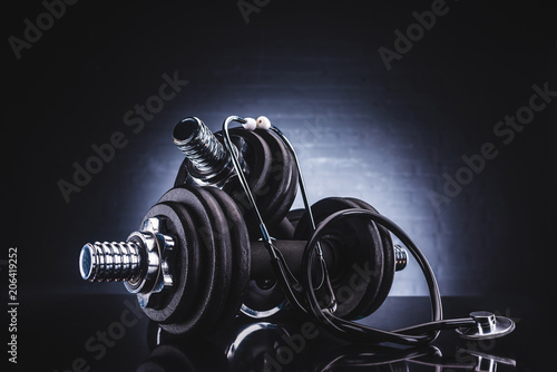 close-up view of stethoscope and dumbbells, healthy lifestyle concept