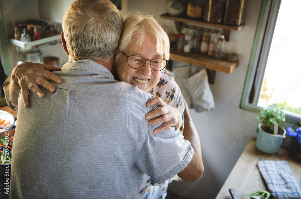 Senior couple hugging in the kitchen Senior couple hugging in the kitchen