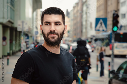 Portrait of young attractive man in the busy crowded street