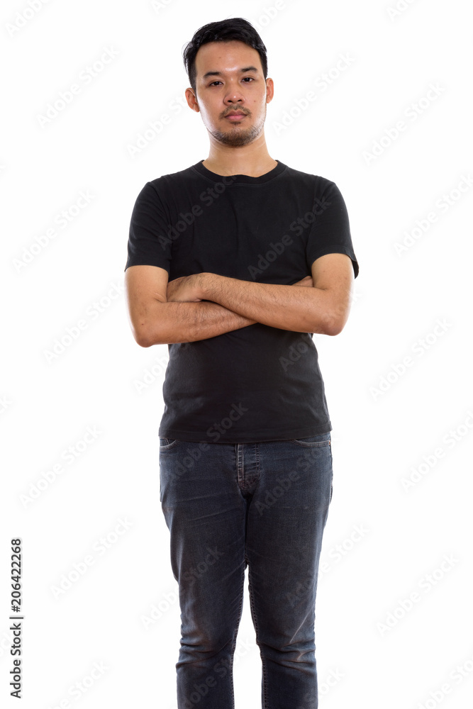 Studio shot of young Asian man standing with arms crossed Studio shot of young Asian man standing with arms crossed