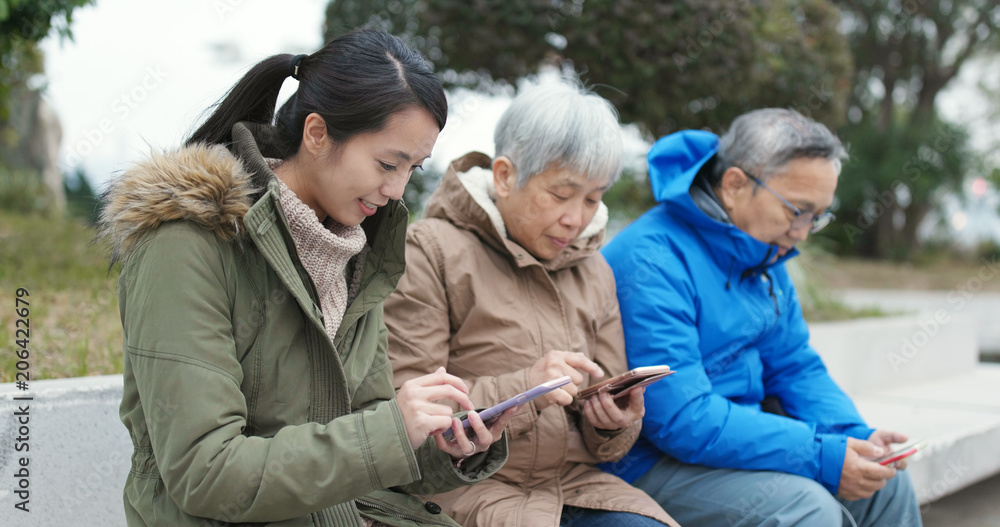 Asian Family using smart phone in the street Asian Family using smart phone in the street
