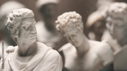 Focus changing between many famous roman sculptures busts made of marble. Closeup shots with focus pull.