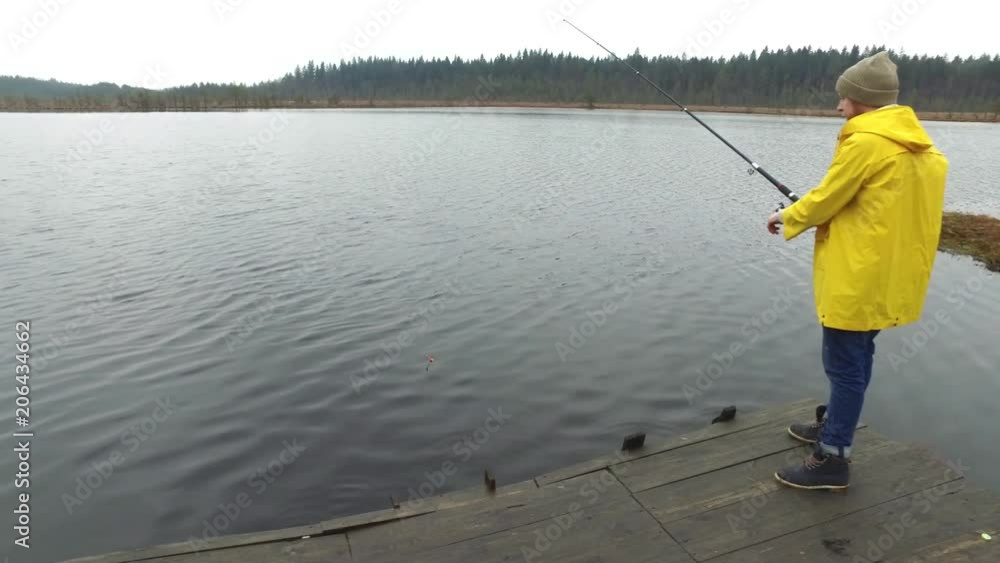 fisherman is fishing on the pier of the lake fisherman is fishing on the pier of the lake