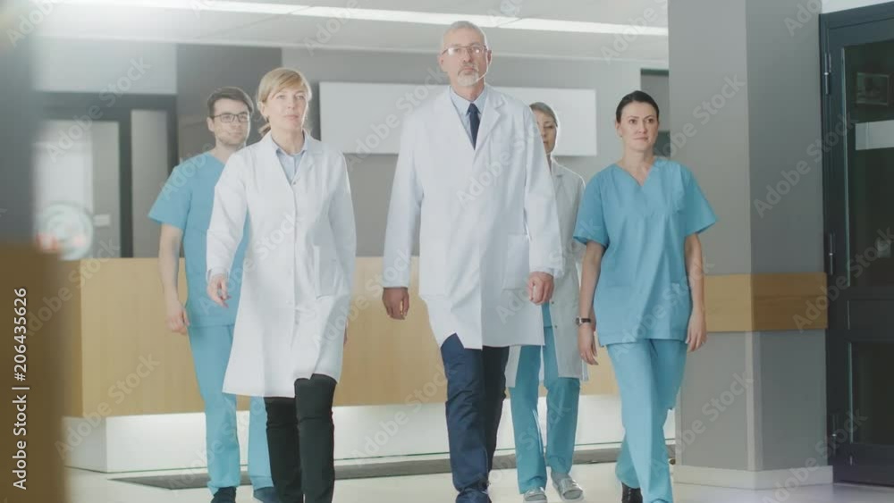 Team of Doctors, Nurses and Assistants Walking through the Lobby of the Hospital. Professional Medical Personnel Working, Saving Lives. Slow Motion. Shot on RED EPIC-W 8K Helium Cinema Camera. Team of Doctors, Nurses and Assistants Walking through the Lobby of the Hospital. Professional Medical Personnel Working, Saving Lives. Slow Motion. Shot on RED EPIC-W 8K Helium Cinema Camera.