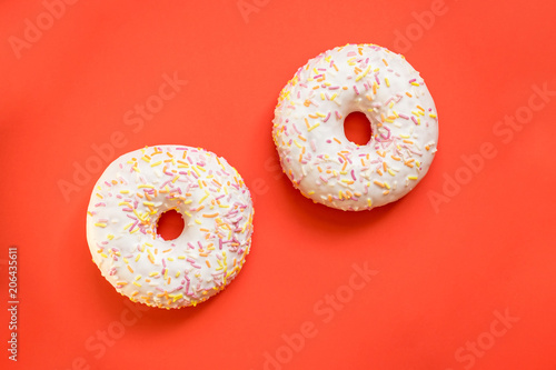Donuts with icing on red background. Sweet donuts, morning dessert.Delicious colorful donuts isolated .Copy space