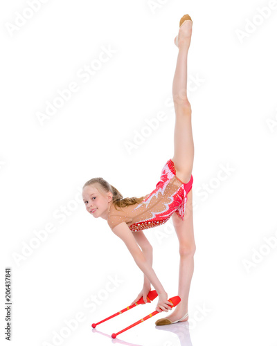 A girl gymnast performs exercises with a mace.