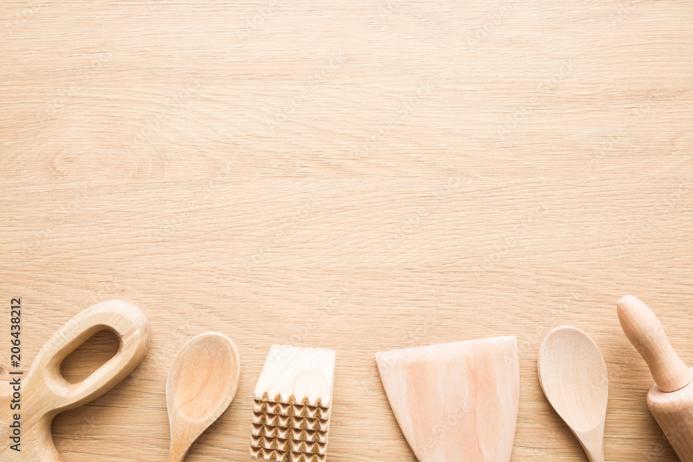 Set of wooden kitchen tools for cooking or baking meal. Utensil for preparing homemade food. Empty place for text or logo on the table. Top view.