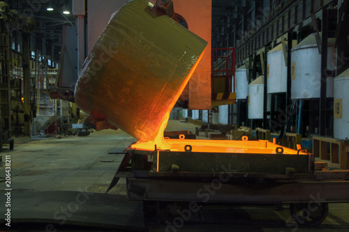 Pouring melted glass into mold in glass factory