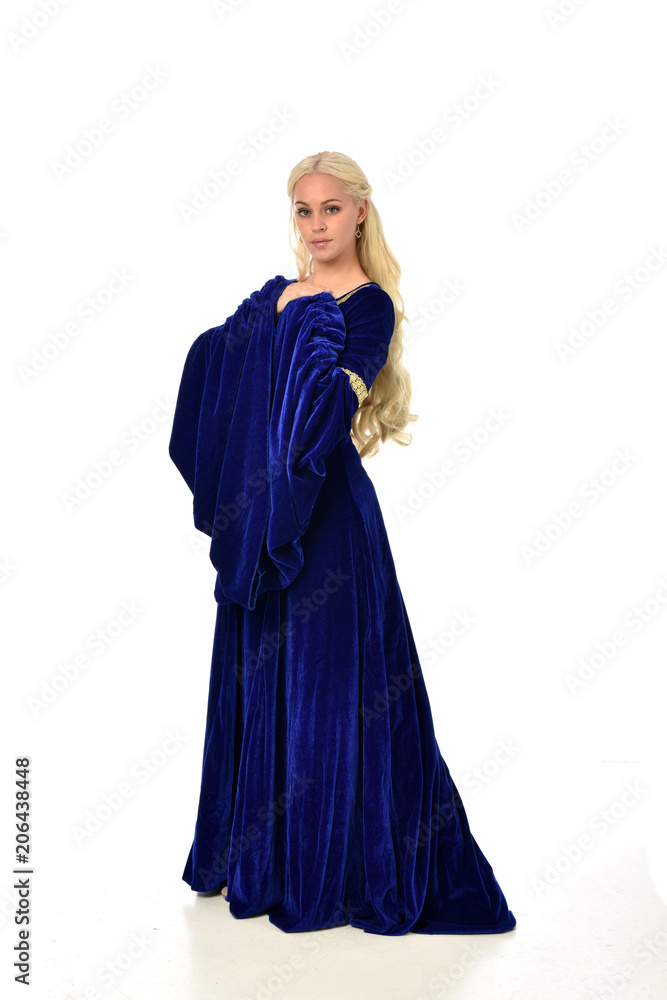 full length portrait of pretty blonde lady wearing  a blue fantasy medieval gown. standing pose on white background.