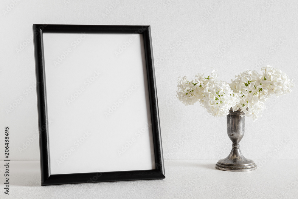 Fresh bouquet of white lilac flowers in the old, vintage vase on white background. Condolence card. Empty place for emotional, sentimental text or quote. Black photo frame. Fresh bouquet of white lilac flowers in the old, vintage vase on white background. Condolence card. Empty place for emotional, sentimental text or quote. Black photo frame.