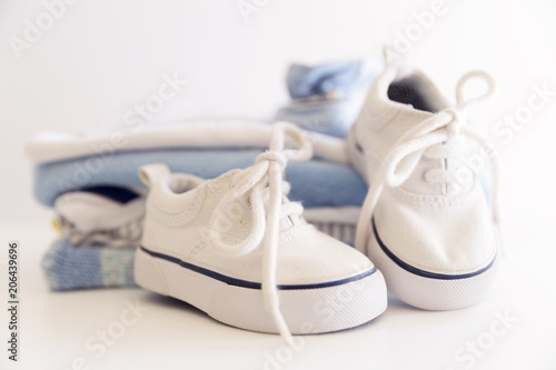 Set of things for a newborn baby boy. Maternal concept. Baby clothes in pile and tiny baby shoes and hat