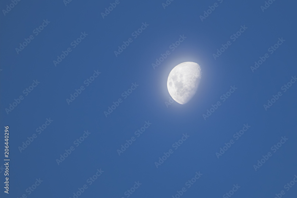 Day time half moon with smooth light behind Day time half moon with smooth light behind