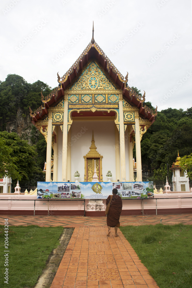 Thai monk walking at Wat Tham Khuha Sawan in Phatthalung, Thailand