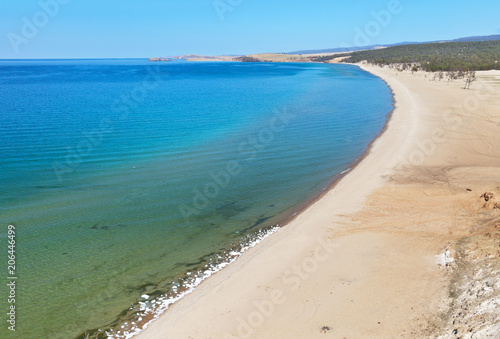 Fototapeta Naklejka Na Ścianę i Meble -  Lake Baikal. Olkhon Island on a sunny May day. The last ice floes are melting on the sandy shore of the beautiful Sarayskiy Gulf. Natural background of a shallow bay with blue clear water