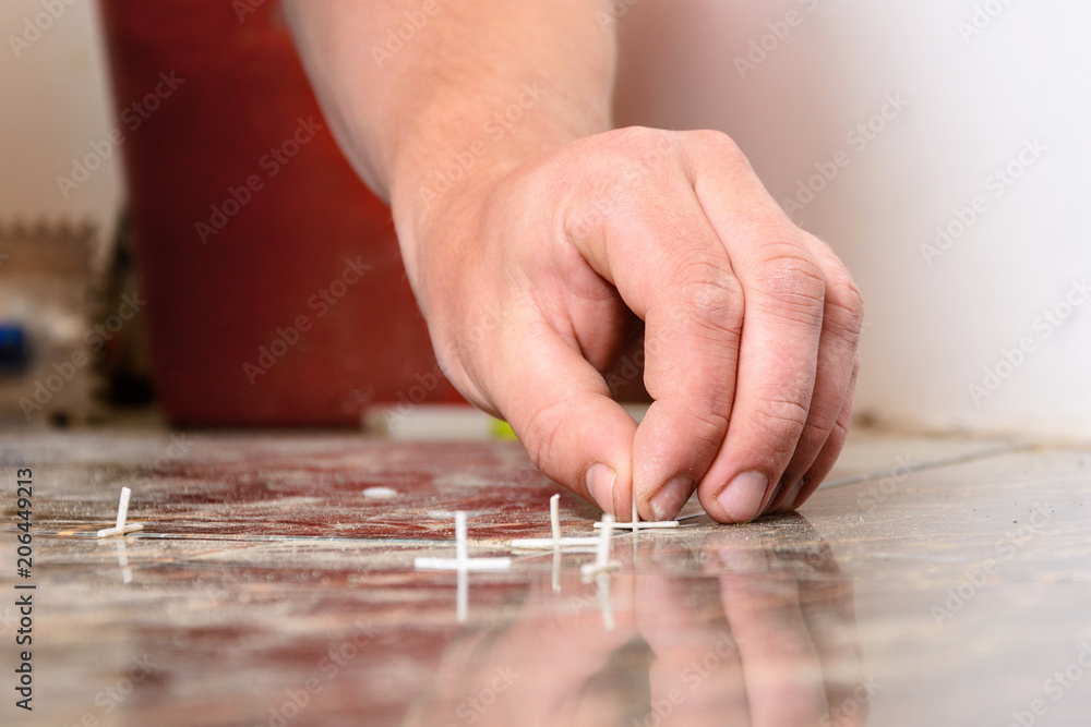 Plastic crosses for laying tiles on the floor are scattered over the tile Plastic crosses for laying tiles on the floor are scattered over the tile