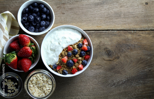 Healthy breakfast, Bowl of yogurt with granola and Fresh fruit on Wood background