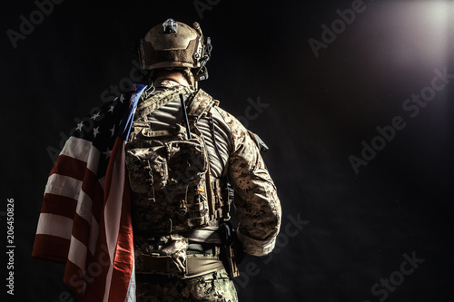 Soldier holding machine gun with national flag