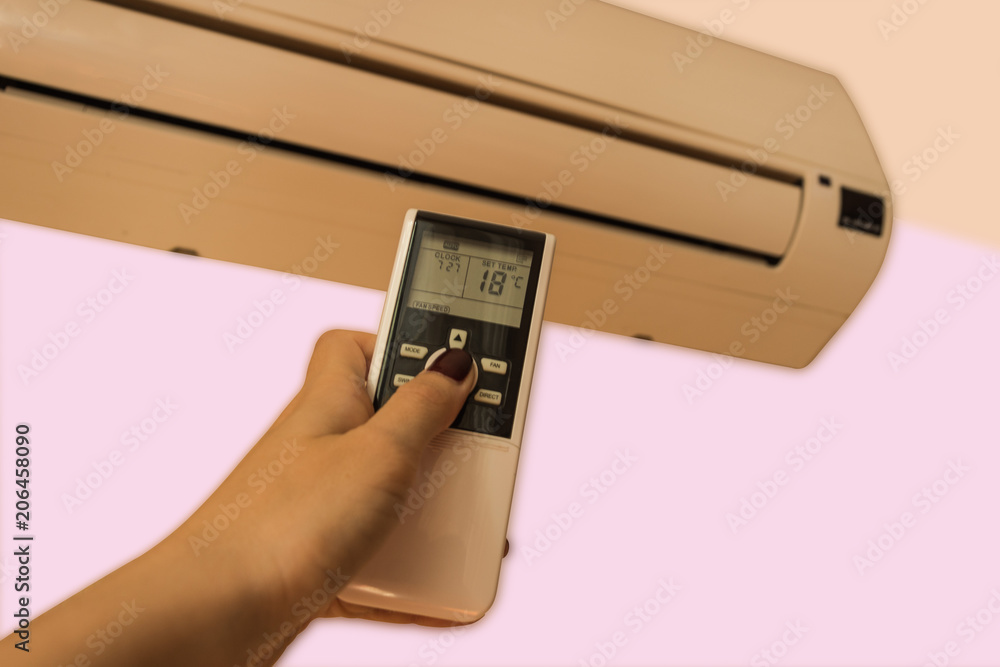 Woman hand using air conditioner remote controller. Woman hand using air conditioner remote controller.