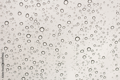 Drops of rain on the tinted windshield of the car. texture
