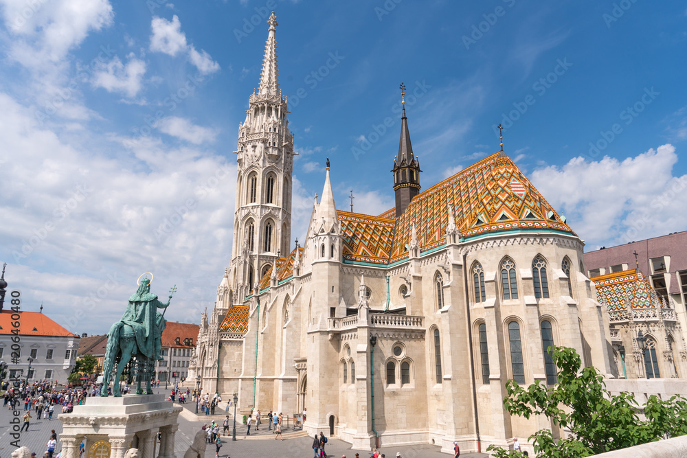 Matthias Church, a church located in Budapest, Hungary, in front of the Fisherman's Bastion at the hill of Buda's Castle District with tourist and hungarian people.