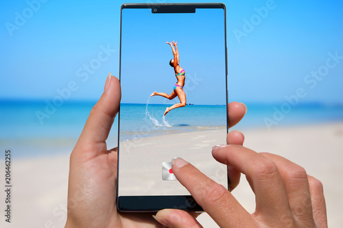 Photography Woman with mobile phone photos woman on the exotic beach.