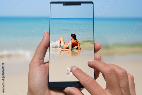Canvas Print Woman with mobile phone photos woman on the exotic beach.