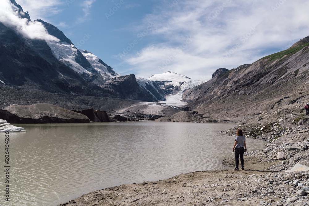 Rear view of woman on lake by glacier