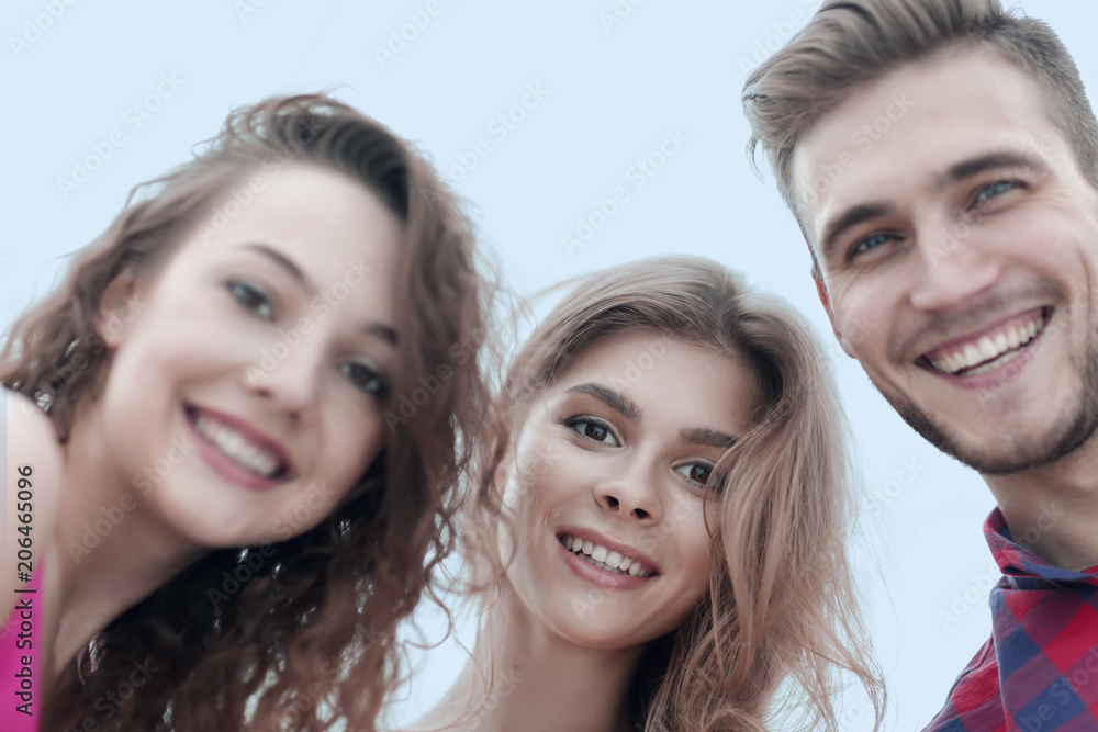 closeup of three young people smiling on white background closeup of three young people smiling on white background