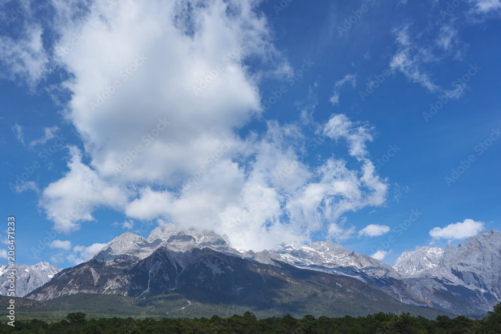 Landscape view of Jade Dragon Snow Mountain with blue sky and could. It`s famous place in China for travel.