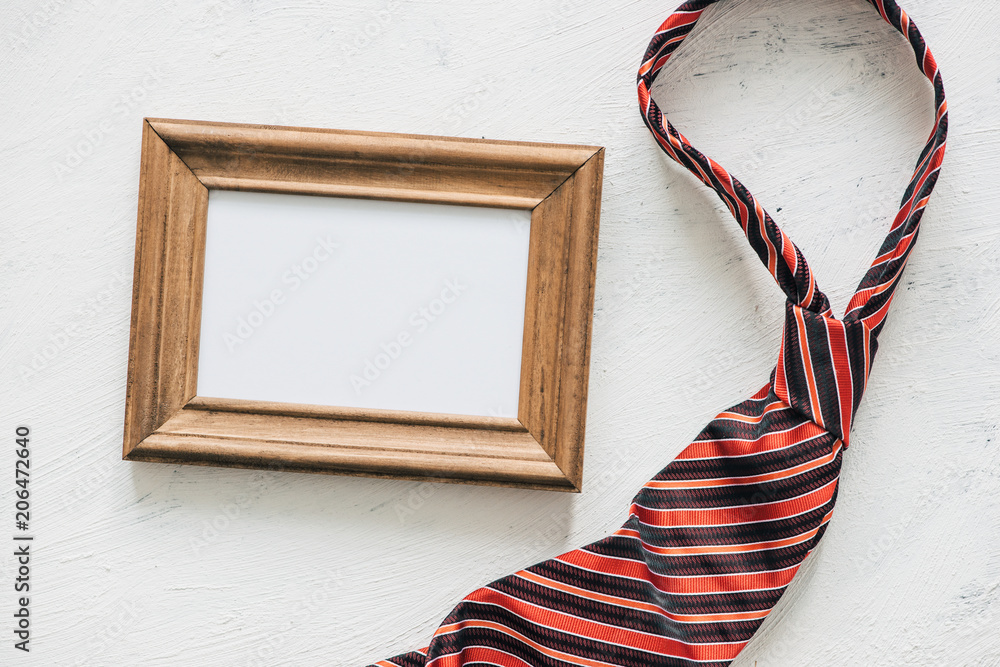 Naklejka premium Flatlay, necktie and blank frame. Father's day concept