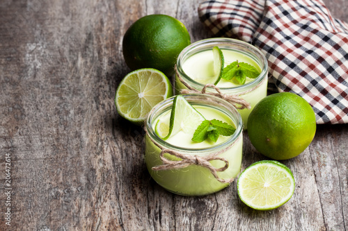 Natural  lime yogurt in a small glass jar on wooden table © lena_zajchikova
