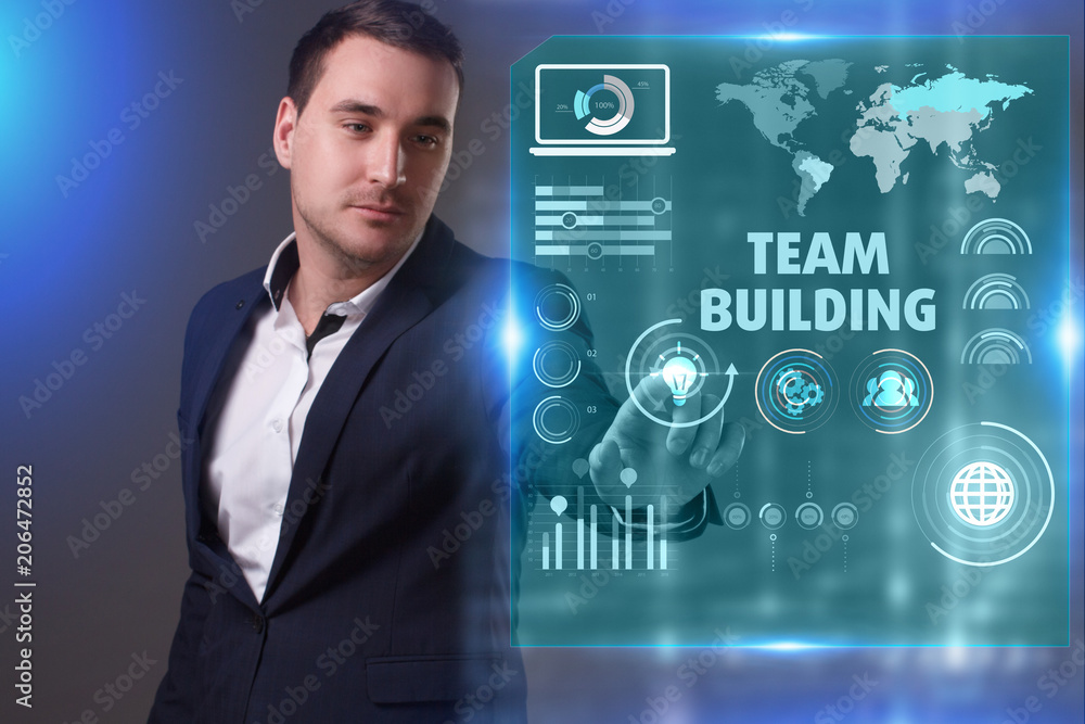 Business, Technology, Internet and network concept. Young businessman working on a virtual screen of the future and sees the inscription: Team building Business, Technology, Internet and network concept. Young businessman working on a virtual screen of the future and sees the inscription: Team building