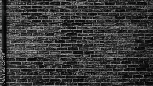 Black brick wall with drain pipe - urban grunge background
