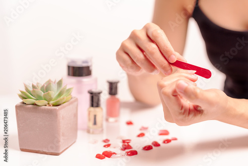 women manicure and attaches a nail shape during the procedure of nail extensions with gel at home. Fashion and Beauty concept