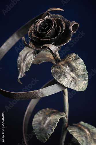 The broze rose with a tape made of metal, on black background. photo