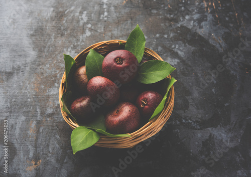 Fresh Kokum or Garcinia indica fruit from India isolated over white or in cane basket with leaves. selective focus photo