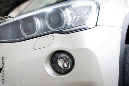 The headlamp of the new clean white sports car is of aggressive form with a part of the bonnet and black wheel, bumper and partronik.