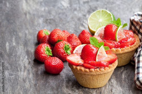 Egg custard  tarts with fresh strawberry and lime on wooden table