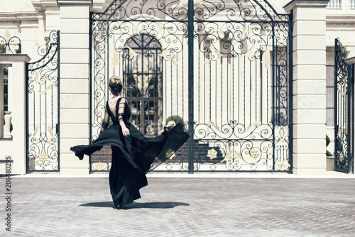 Woman in a black dress outdoor portrait. Classic vintage style. Shot from the...