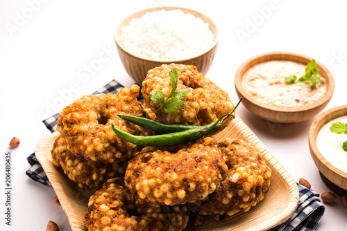 Sabudana vada or Sago fried cake served with peanut chutney over moody background, popular fasting recipe from India. 