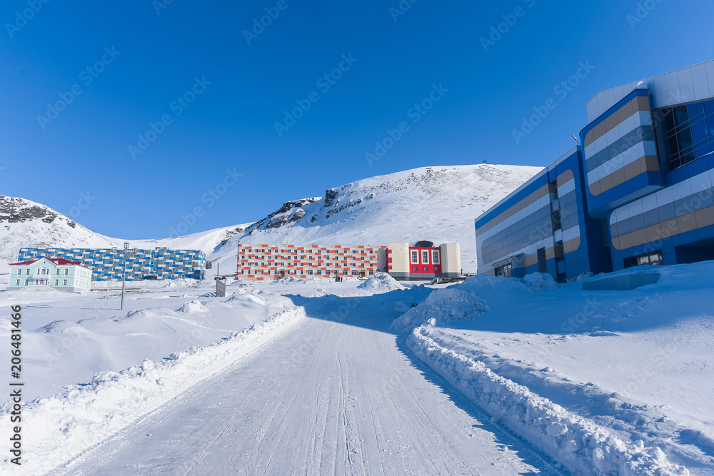 Landscape of the Russian city of Barentsburg on the Spitsbergen archipelago in the winter in the Arctic In sunny weather and blue sky Landscape of the Russian city of Barentsburg on the Spitsbergen archipelago in the winter in the Arctic In sunny weather and blue sky