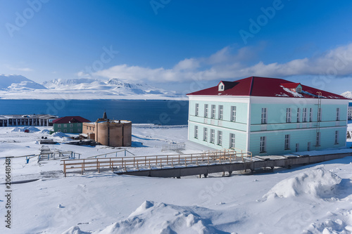 Landscape of the Russian city of Barentsburg on the Spitsbergen archipelago in the winter in the Arctic In sunny weather and blue sky