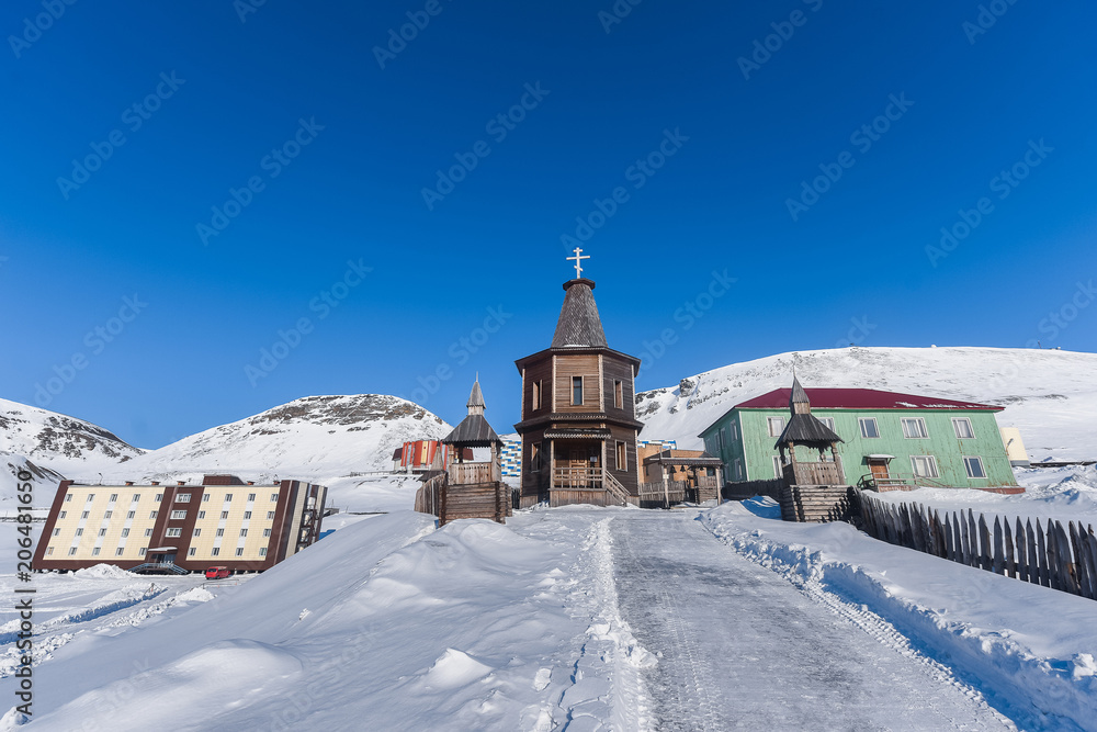 Landscape of the Russian city of Barentsburg on the Spitsbergen archipelago in the winter in the Arctic In sunny weather and blue sky