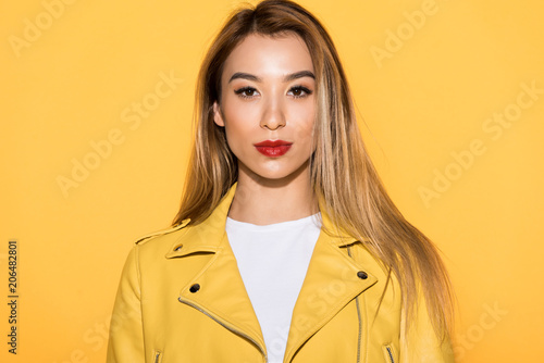 portrait of young stylish asian woman isolated on yellow background