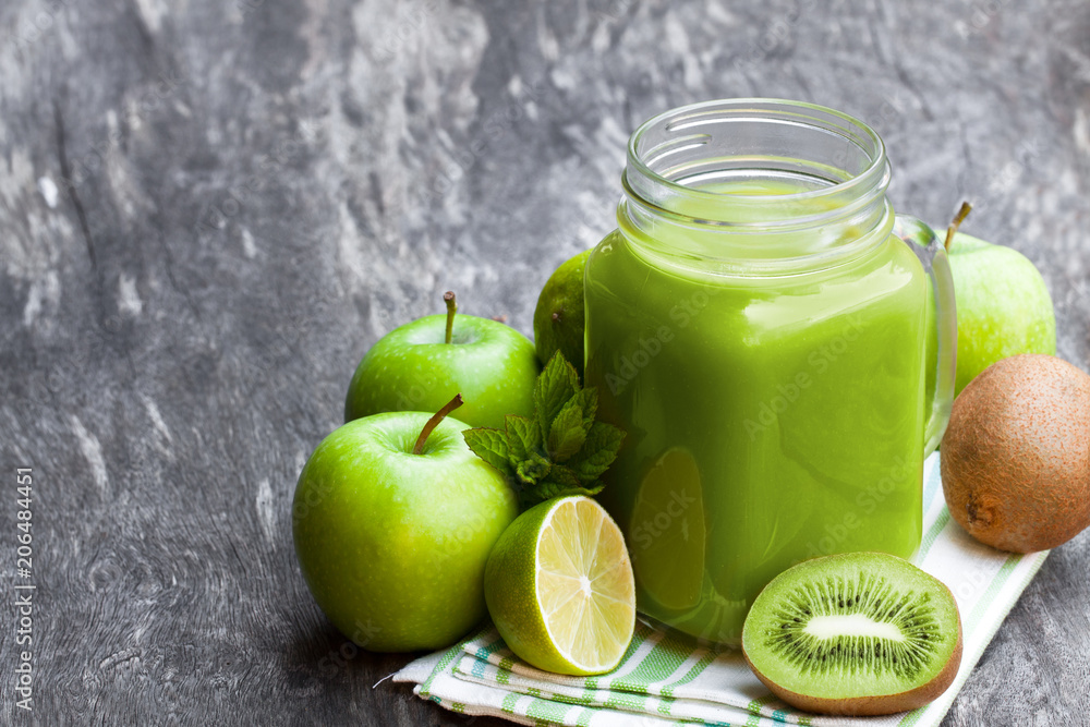 Fresh smoothie with green fruits in a glass jar mug on wooden table Fresh smoothie with green fruits in a glass jar mug on wooden table